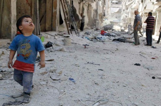 طفل في حلب ينظر إلى مبانٍ دمرها قصف نظام الأسد أحياءً في المدينة