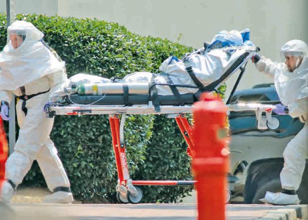 Medical workers roll patient Nancy Writebol into Emory University Hospital in Atlanta