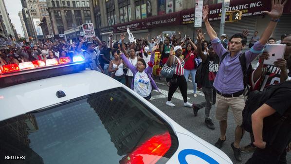 Protester raise their hands during a march up Broadway during a peaceful demonstration, as communities react to the shooting of Michael Brown in New York