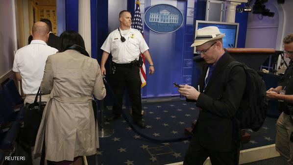 A U.S. Secret Service agent watches as members of the media evacuate the White House complex moments after U.S. President Barack Obama and his family left for the presidential retreat, Camp David, in Maryland