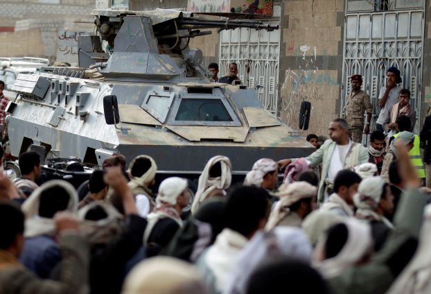 Followers of the Shi'ite Houthi movement march past a military vehicle during an anti-government demonstration in Sanaa
