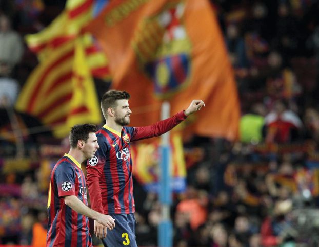 Barcelona's Messi and his teammate Pique leave the pitch after their Champions League last 16 second leg soccer match against Manchester City