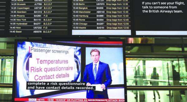 شاشة تلفزيونية تعرض خبرا عن بدء فحص المسافرين القادمين من الدول المتضررة بإيبولا