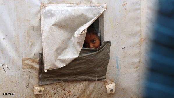 A child, who is internally displaced due to fighting between rebels and forces loyal to Syrian President Bashar al-Assad, looks out of his tent window in Ekda village refugee camp, beside the Syrian-Turkish border in northern Aleppo