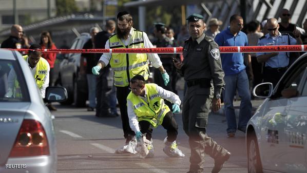 Members of the Israeli Zaka emergency response team work at the scene of a stabbing in Tel Aviv