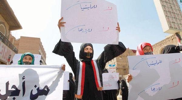 يمنية ترفع لافتة كتب عليها «لا للميليشيات.. لا للإرهاب»