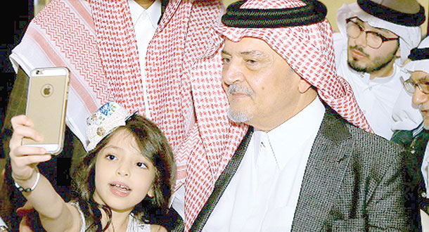 طفلة تلتقط صورة «سيلفي» مع الأمير سعود الفيصل