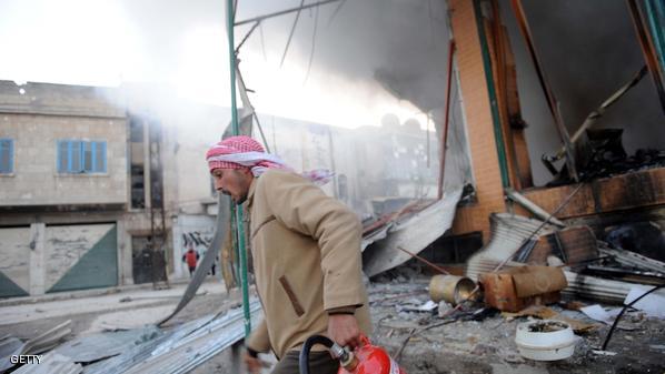A Syrian man runs with a fire extinguish