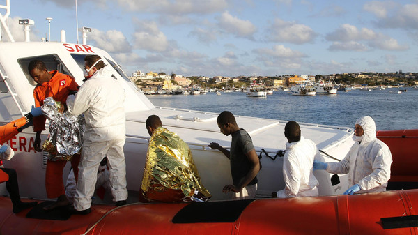 Migrants who survived a shipwreck arrive at the Lampedusa harbour