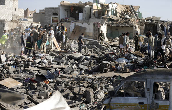 Civil defence workers and people search for survivors under the rubble of houses destroyed by an air strike near Sanaa Airport