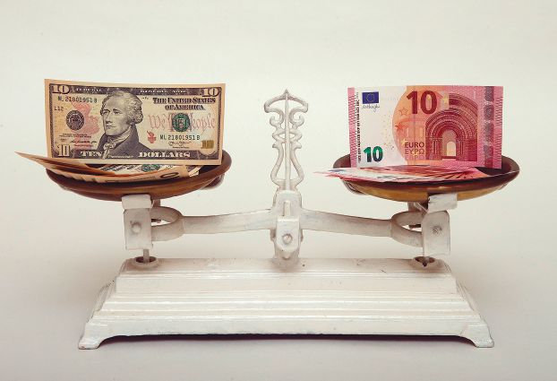A file photo illustration shows U.S. Dollar and Euro banknotes on a pair of scales in Vienna