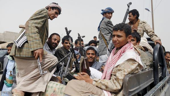 Houthi fighters ride a patrol truck outside Sanaa Airport