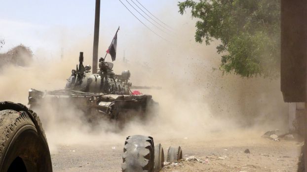 Anti-Houthi fighters of the Southern Popular Resistance fire from a tank in Yemen's southern port city of Aden