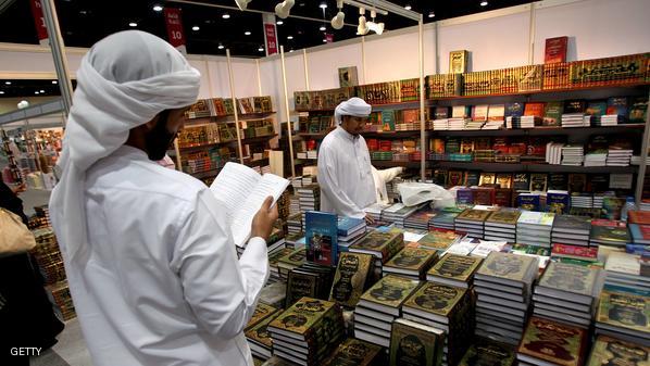 Emirati men looks through books displaye