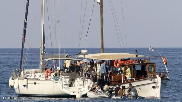 Pro-Palestinian activists embark on a sailing boat, to be part of a small flotilla that media reports say will try to challenge Israel's sea blockade of the Gaza Strip, in the open sea near Plaka on the island of Crete, Greece