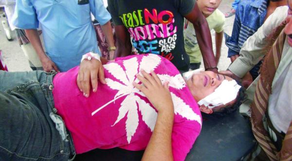 يمنيون يحاولون إسعاف رجل أصيب بجروح خطيرة